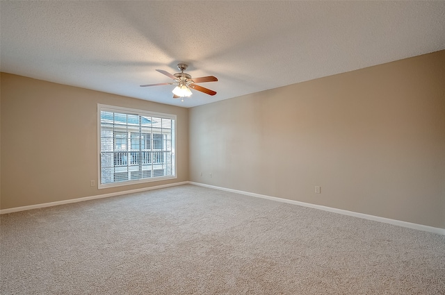 carpeted spare room featuring ceiling fan and a textured ceiling