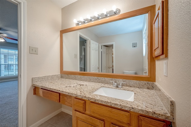 bathroom featuring ceiling fan, tile patterned flooring, vanity, and toilet