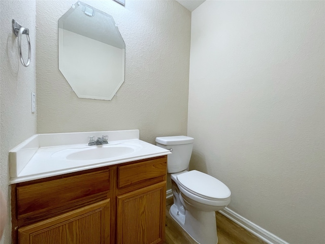 bathroom featuring wood-type flooring, vanity, and toilet