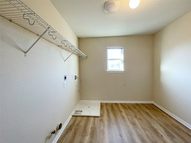 washroom with light hardwood / wood-style flooring, hookup for an electric dryer, and hookup for a washing machine