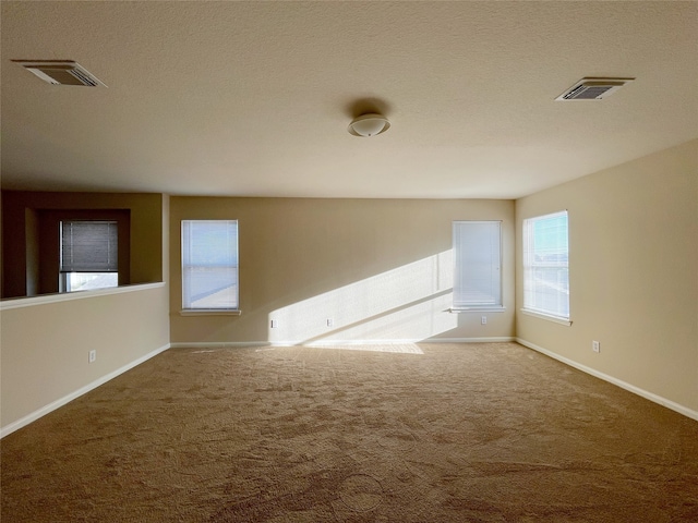 carpeted empty room featuring a textured ceiling