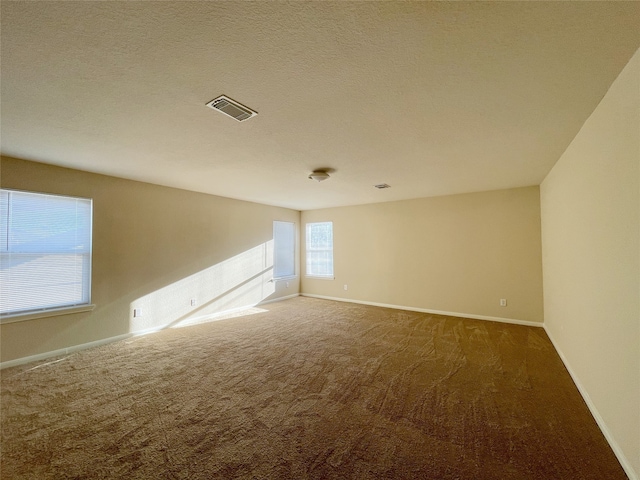 carpeted spare room featuring a textured ceiling