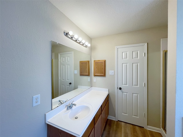 bathroom with hardwood / wood-style flooring, a textured ceiling, and vanity