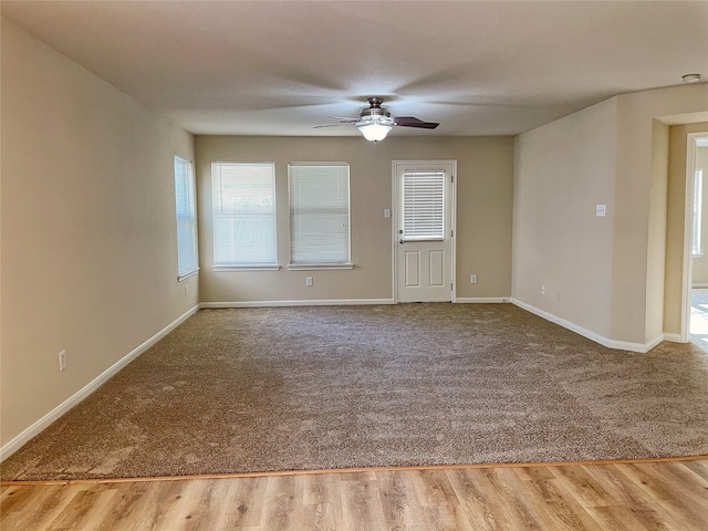 carpeted empty room featuring ceiling fan