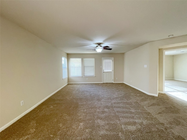 carpeted spare room featuring ceiling fan