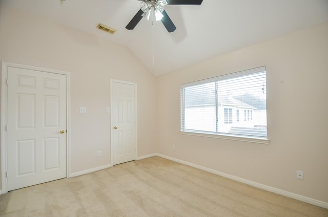 unfurnished bedroom with ceiling fan, light colored carpet, and vaulted ceiling