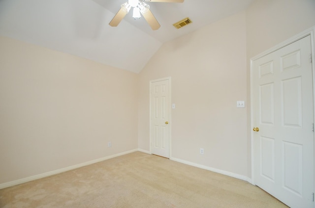 empty room with light colored carpet, ceiling fan, and lofted ceiling