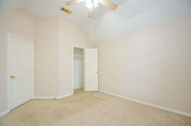 unfurnished bedroom featuring light colored carpet, vaulted ceiling, and ceiling fan