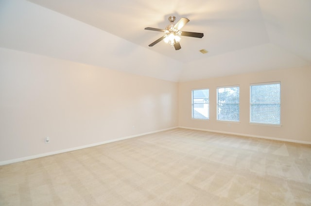 carpeted empty room featuring ceiling fan and vaulted ceiling