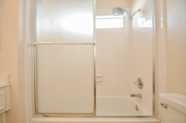 full bathroom featuring toilet, combined bath / shower with glass door, and vanity