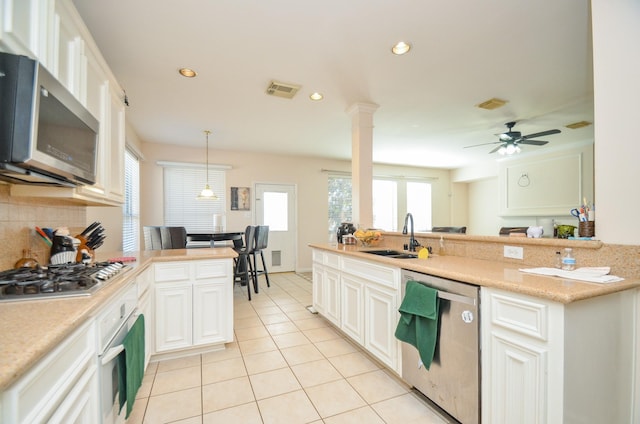 kitchen featuring pendant lighting, white cabinets, sink, ceiling fan, and appliances with stainless steel finishes