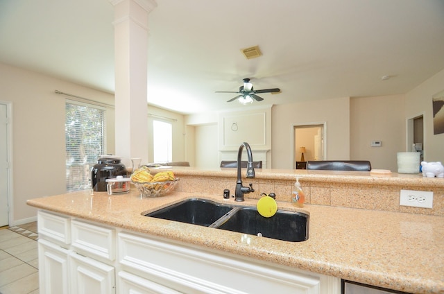 kitchen featuring white cabinetry, sink, ceiling fan, and light stone counters