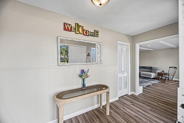 hallway featuring hardwood / wood-style floors, a textured ceiling, and wooden walls