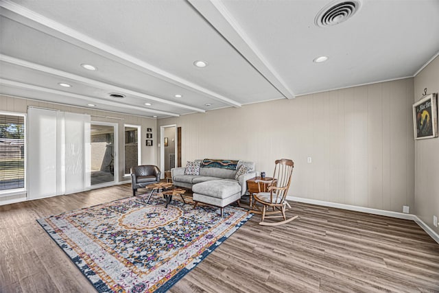 living room with hardwood / wood-style flooring, beam ceiling, and wood walls