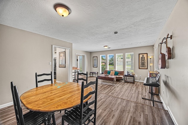 dining area featuring hardwood / wood-style floors and a textured ceiling