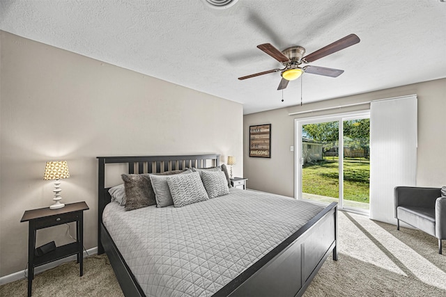 carpeted bedroom featuring access to exterior, ceiling fan, and a textured ceiling