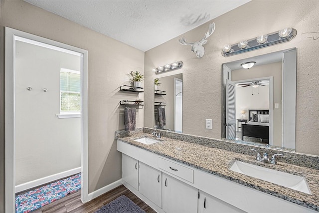 bathroom featuring ceiling fan, vanity, a textured ceiling, and hardwood / wood-style flooring