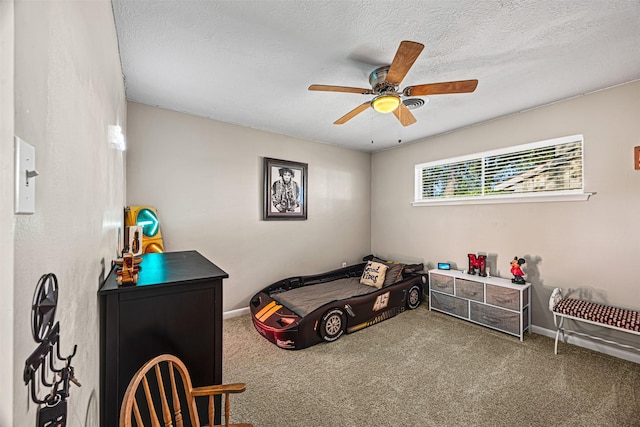 carpeted bedroom featuring ceiling fan and a textured ceiling