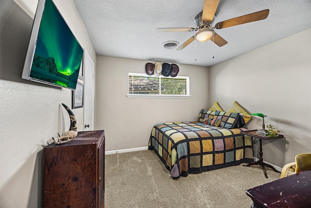 carpeted bedroom featuring ceiling fan and a textured ceiling