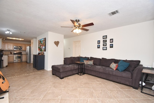 living room with a textured ceiling and ceiling fan