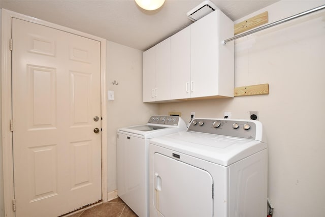 laundry room featuring tile patterned floors, cabinets, and washing machine and dryer