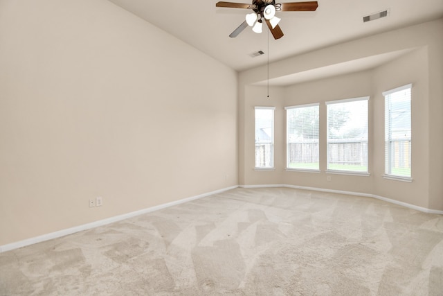 empty room with light carpet, ceiling fan, and vaulted ceiling