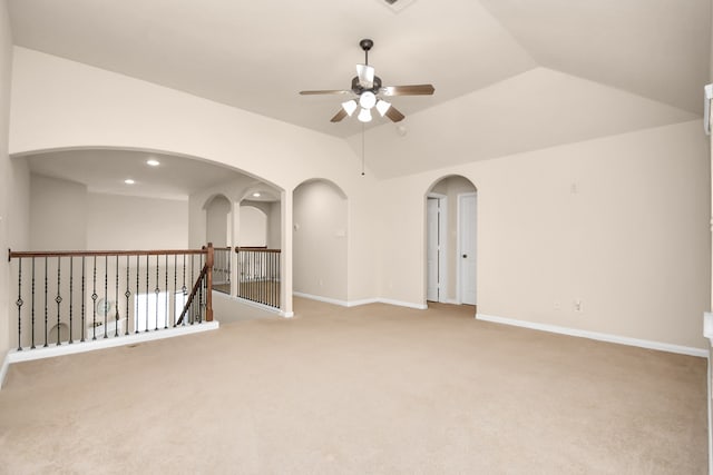 carpeted spare room featuring ceiling fan and vaulted ceiling