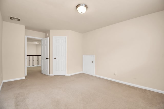 unfurnished bedroom featuring light colored carpet and a closet