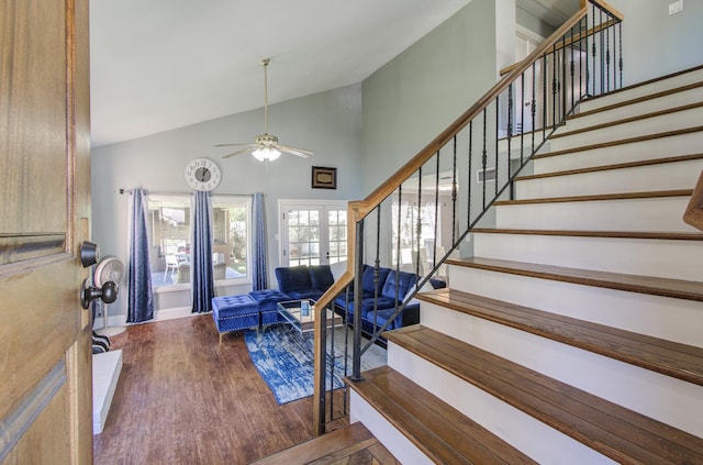 stairs featuring ceiling fan, hardwood / wood-style floors, high vaulted ceiling, and french doors