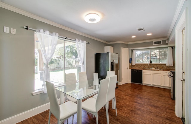 dining space with dark wood-type flooring, a healthy amount of sunlight, and ornamental molding