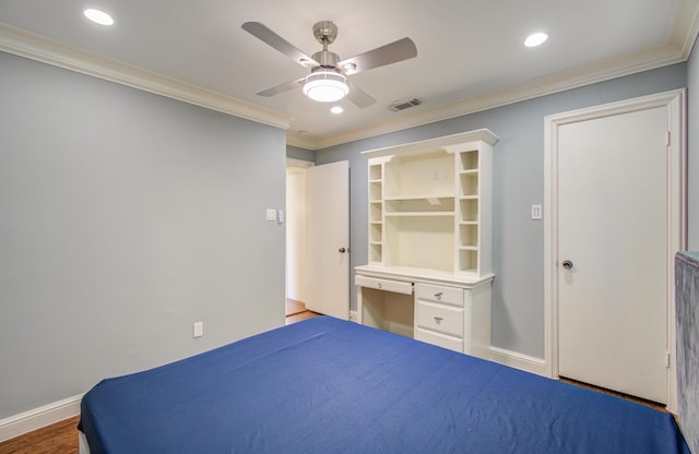 unfurnished bedroom with a walk in closet, ceiling fan, crown molding, wood-type flooring, and built in desk