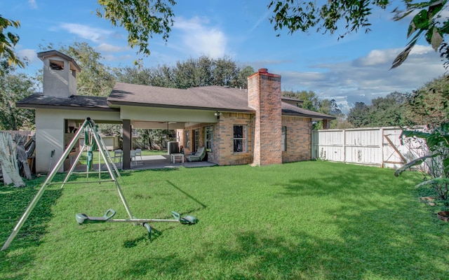 rear view of property featuring a patio area and a yard