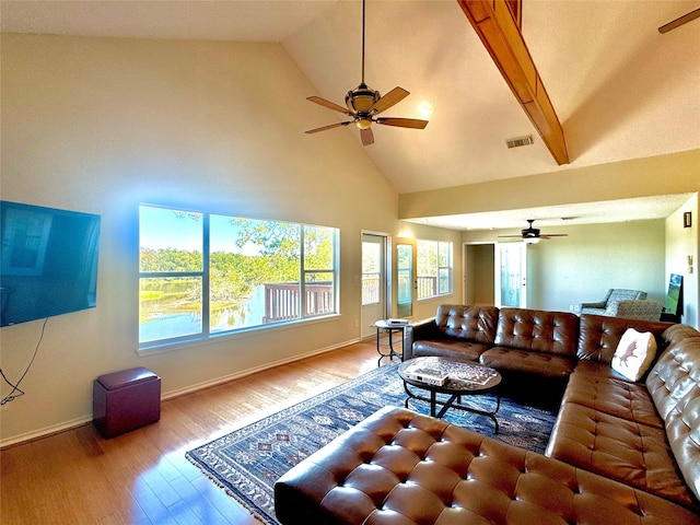 living room with beam ceiling, hardwood / wood-style flooring, high vaulted ceiling, and ceiling fan