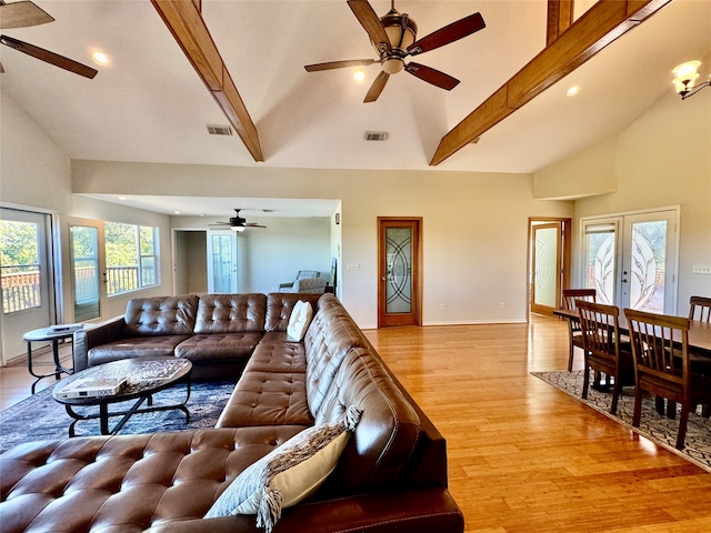 living room with beam ceiling, plenty of natural light, high vaulted ceiling, and light hardwood / wood-style floors