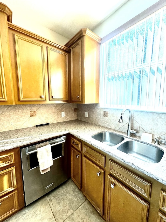 kitchen featuring sink, stainless steel dishwasher, decorative backsplash, light stone countertops, and light tile patterned floors