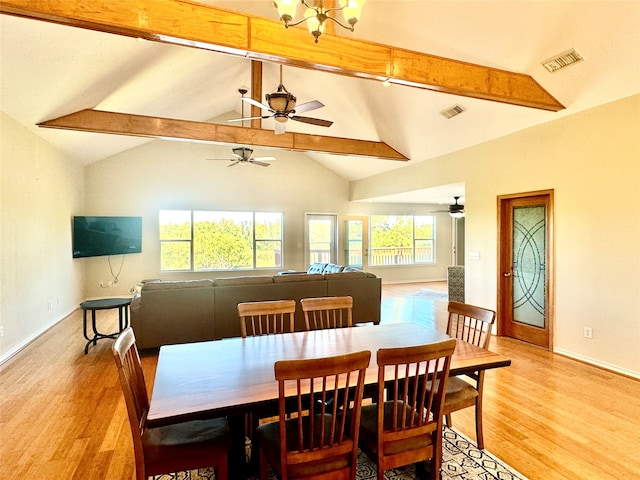 dining area featuring lofted ceiling with beams, ceiling fan with notable chandelier, and light wood-type flooring