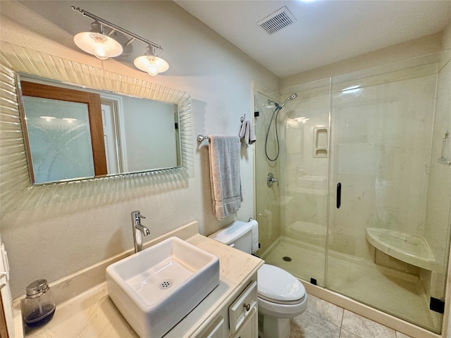 bathroom featuring tile patterned floors, vanity, an enclosed shower, and toilet