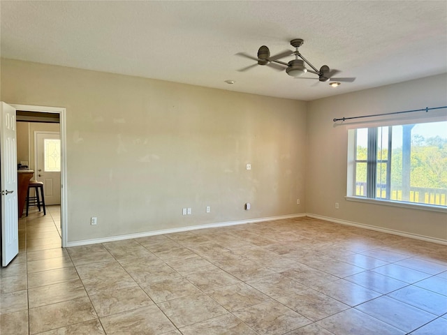 113 Cottonwood Rd, Trinity, TX 75862 - empty room with light tile patterned floors, a ceiling fan, baseboards, and a textured ceiling