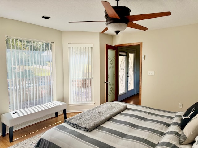 bedroom with multiple windows, a textured ceiling, dark hardwood / wood-style flooring, and ceiling fan