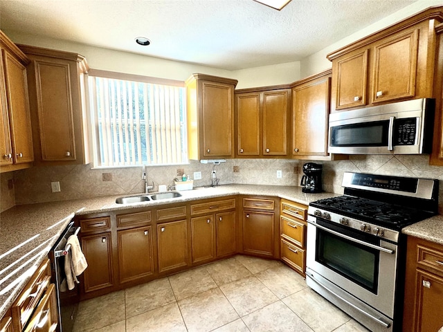 kitchen with sink, light tile patterned floors, stainless steel appliances, and tasteful backsplash