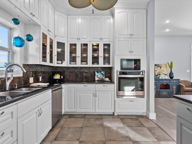 kitchen with white cabinets, appliances with stainless steel finishes, decorative backsplash, and sink