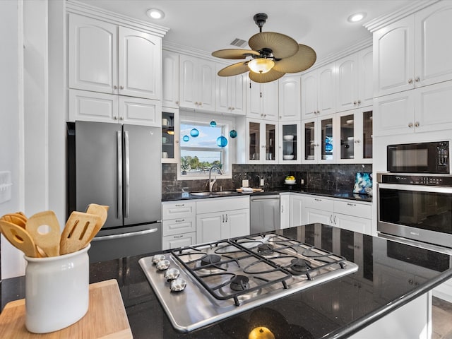 kitchen featuring white cabinets, ceiling fan, stainless steel appliances, and tasteful backsplash