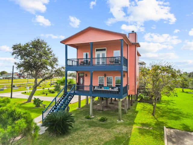 rear view of property featuring a lawn and a porch