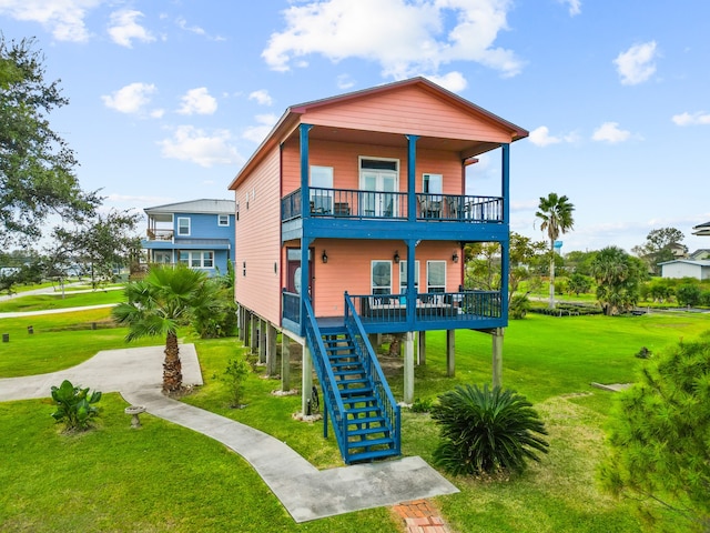 back of property featuring a lawn, a balcony, and covered porch