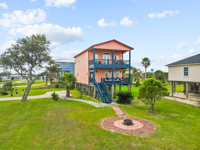 rear view of property featuring a lawn and a balcony