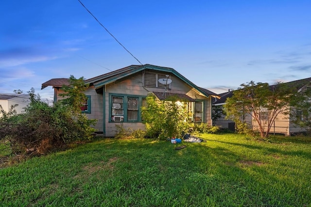 view of front of home with cooling unit and a front yard