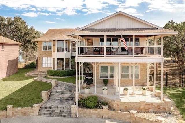 back of house with a balcony, a yard, and a patio