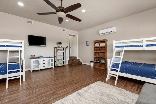1464 Lakeside Dr W, Canyon Lake, TX 78133 - bedroom featuring ceiling fan, dark hardwood / wood-style flooring, an AC wall unit, and a textured ceiling