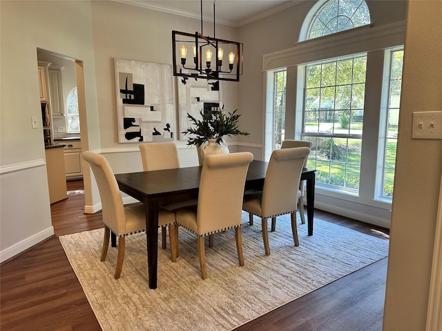 dining area with crown molding, hardwood / wood-style floors, and an inviting chandelier