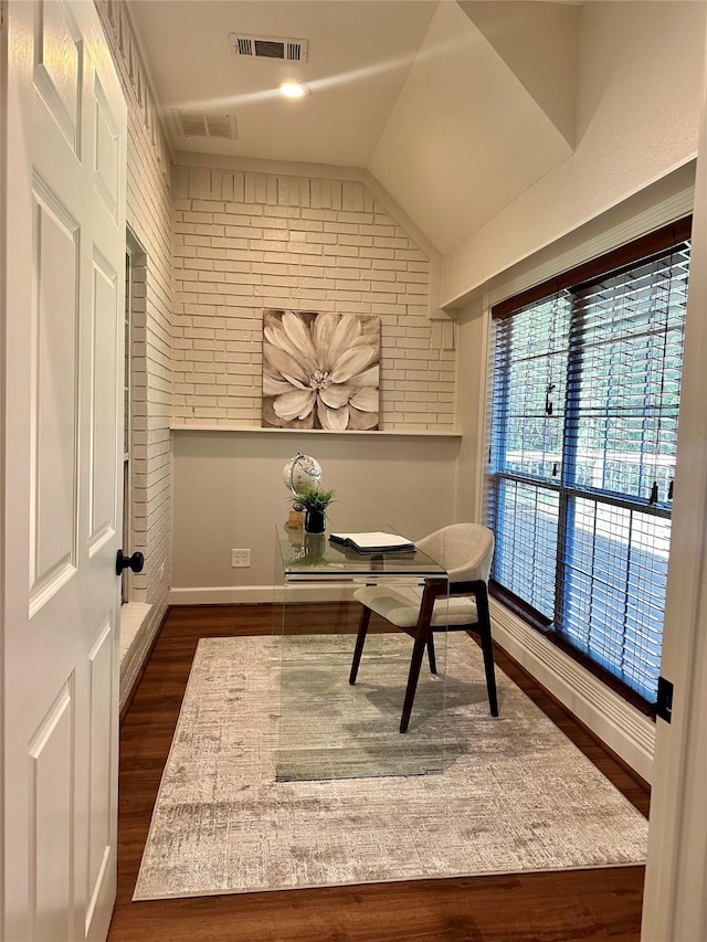 office area with lofted ceiling, brick wall, and dark hardwood / wood-style floors